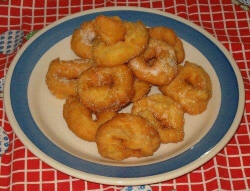 Plato con rosquillas de anís recién fritas espolvoreadas con azúcar